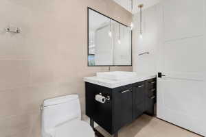 Modern bathroom featuring a dark wood-finish vanity with a white countertop and rectangular vessel sink