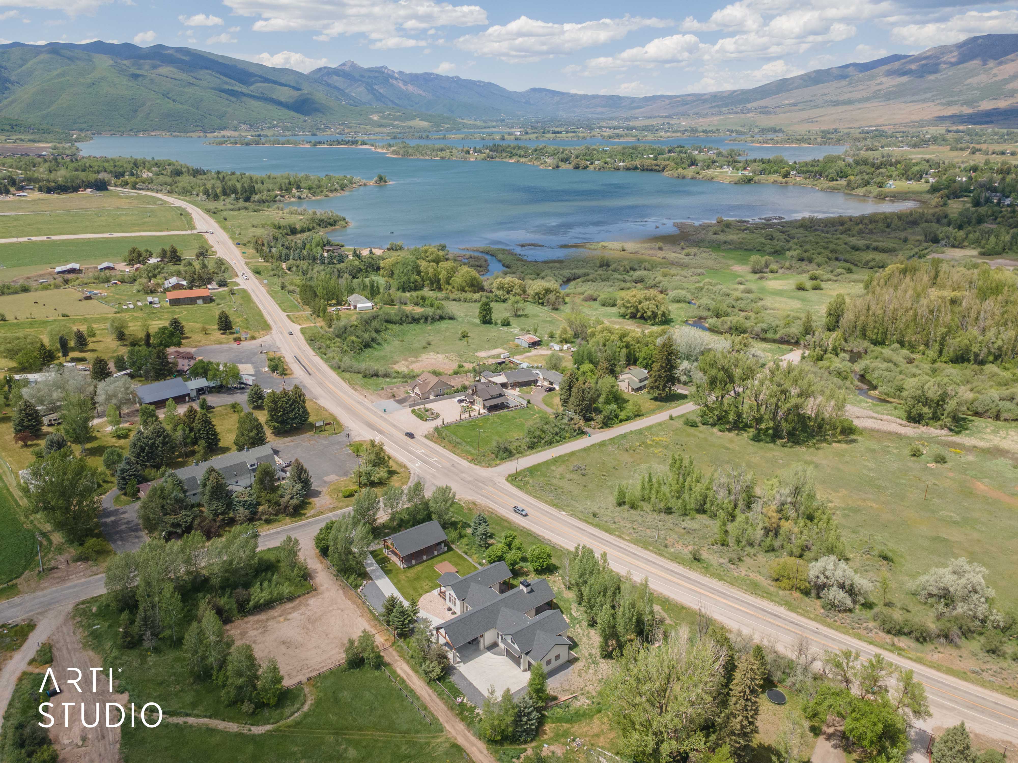 Aerial perspective showcasing a large body of water, distant mountains, and surrounding green landscapes