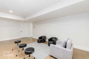 Spacious room featuring light wood-finish flooring, recessed lighting, white walls, and bright white trim