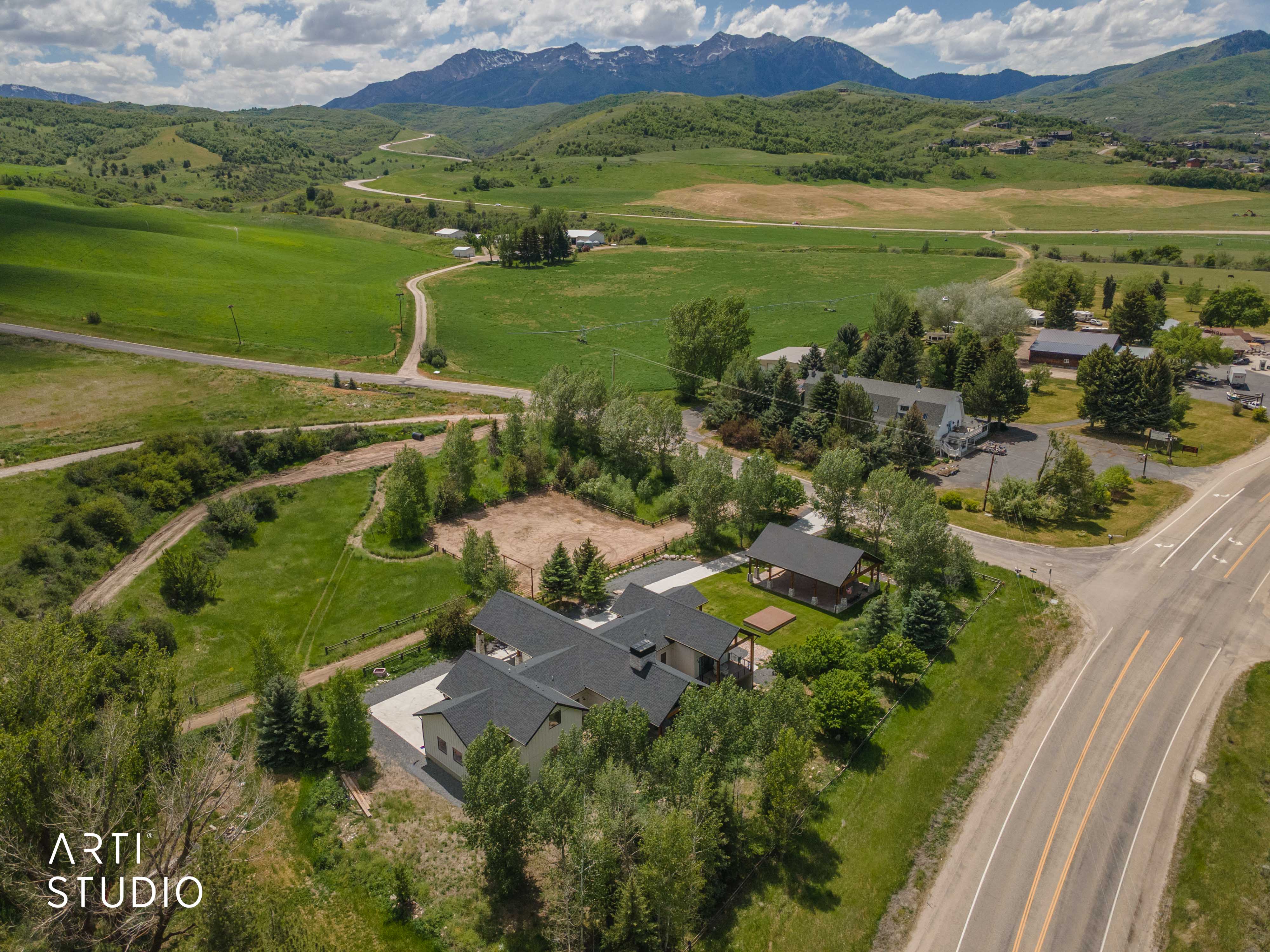 Expansive property with multiple buildings, mature trees, and a paved driveway