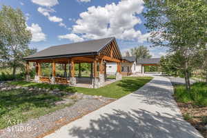 Expansive outdoor pavilion featuring exposed timber framing and stone-clad pillars