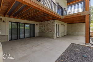 Concrete patio area with exposed wood ceiling joists and decking overhead