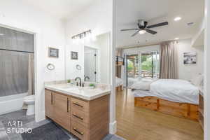 Bathroom vanity featuring wood-finish cabinetry, a light-toned countertop, and a matte black faucet