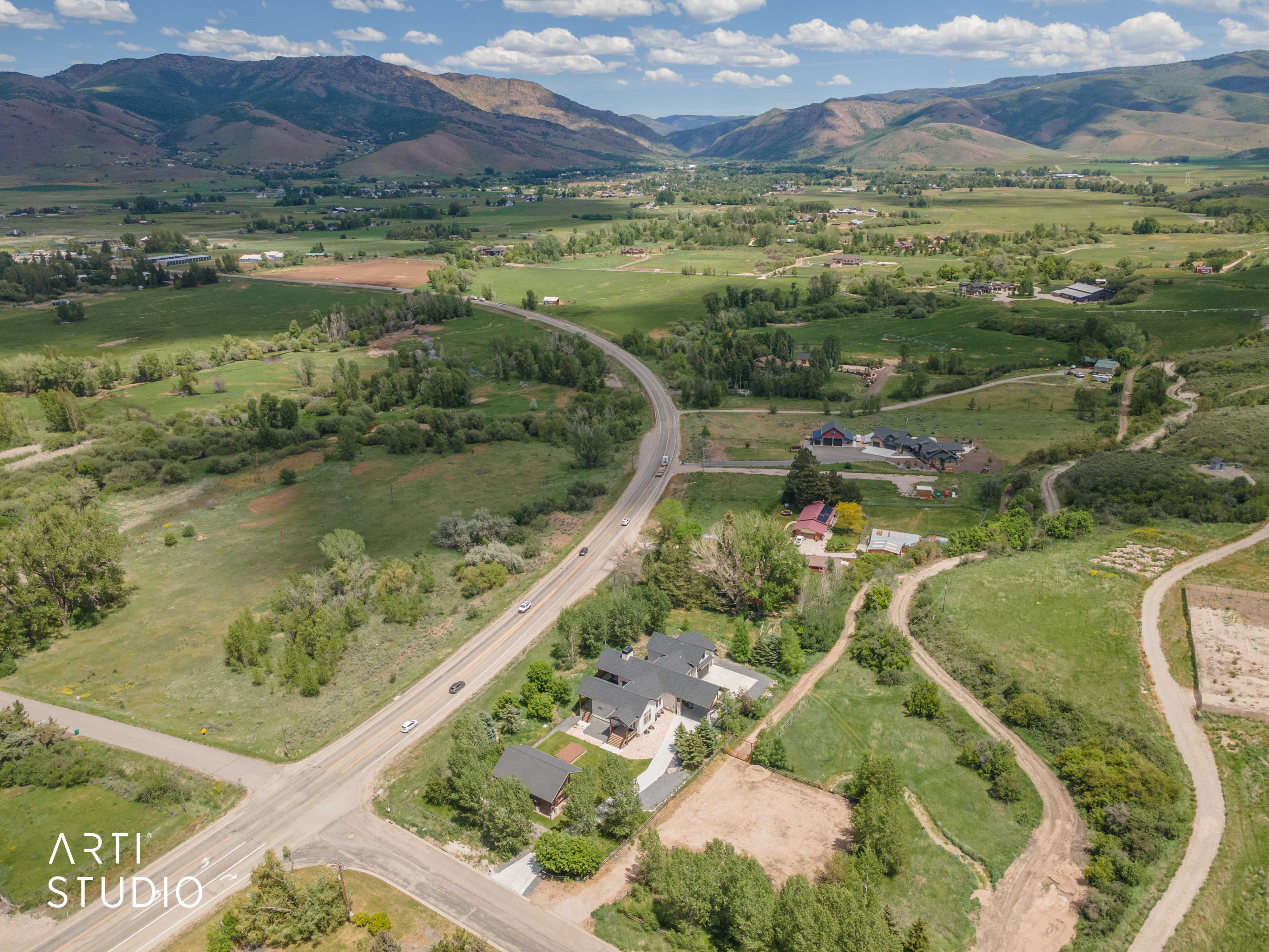 Expansive rural landscape featuring distant mountains and valleys, with scattered residential properties