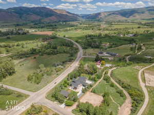 Expansive rural landscape featuring distant mountains and valleys, with scattered residential properties
