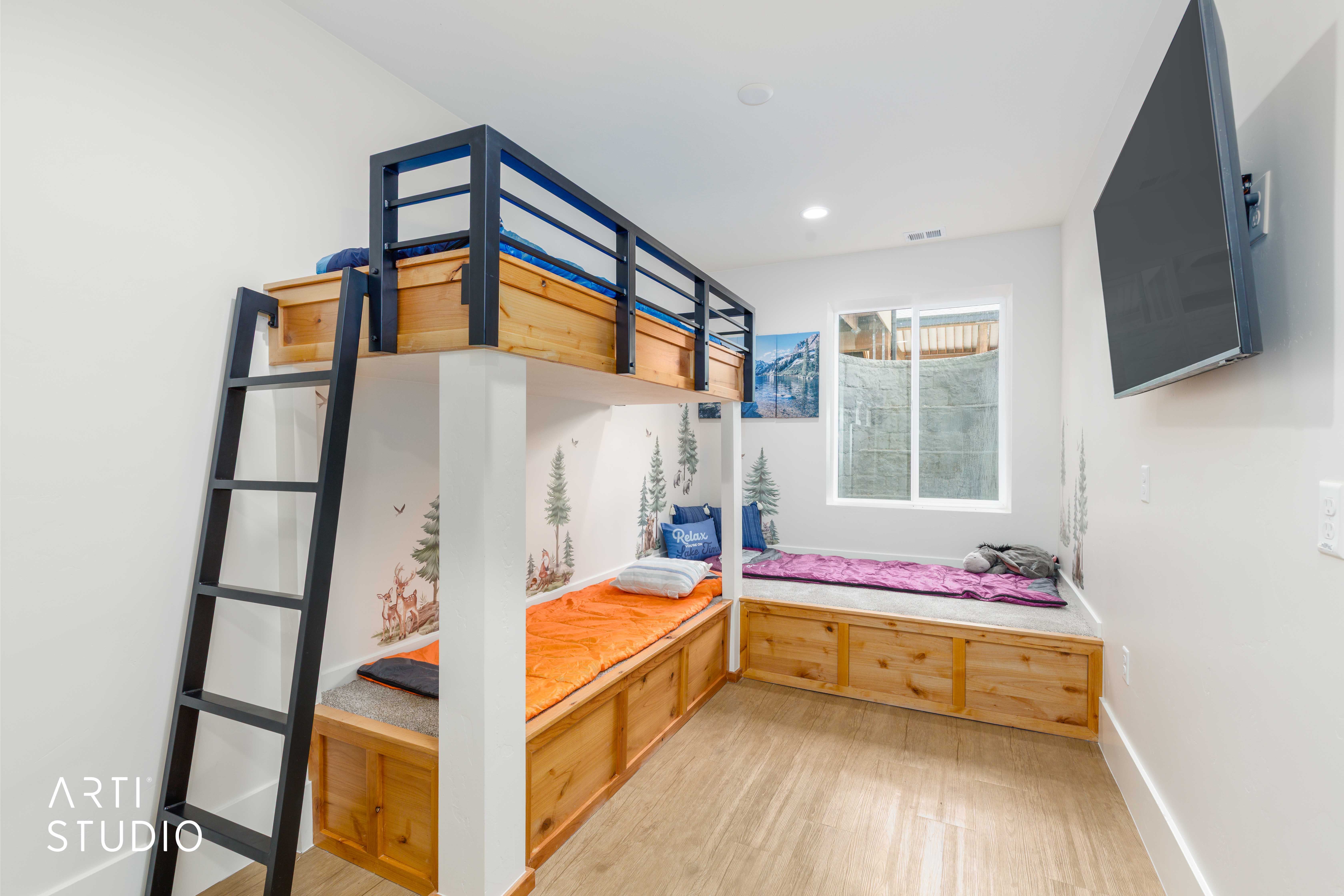 Room featuring a built-in bunk bed with metal framing and a ladder, integrated wood-finish storage benches, a sliding window, and wood-finish flooring