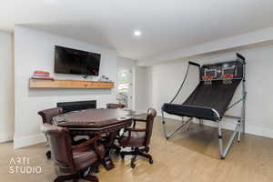 Entertainment room featuring wood-finish flooring and a white color palette