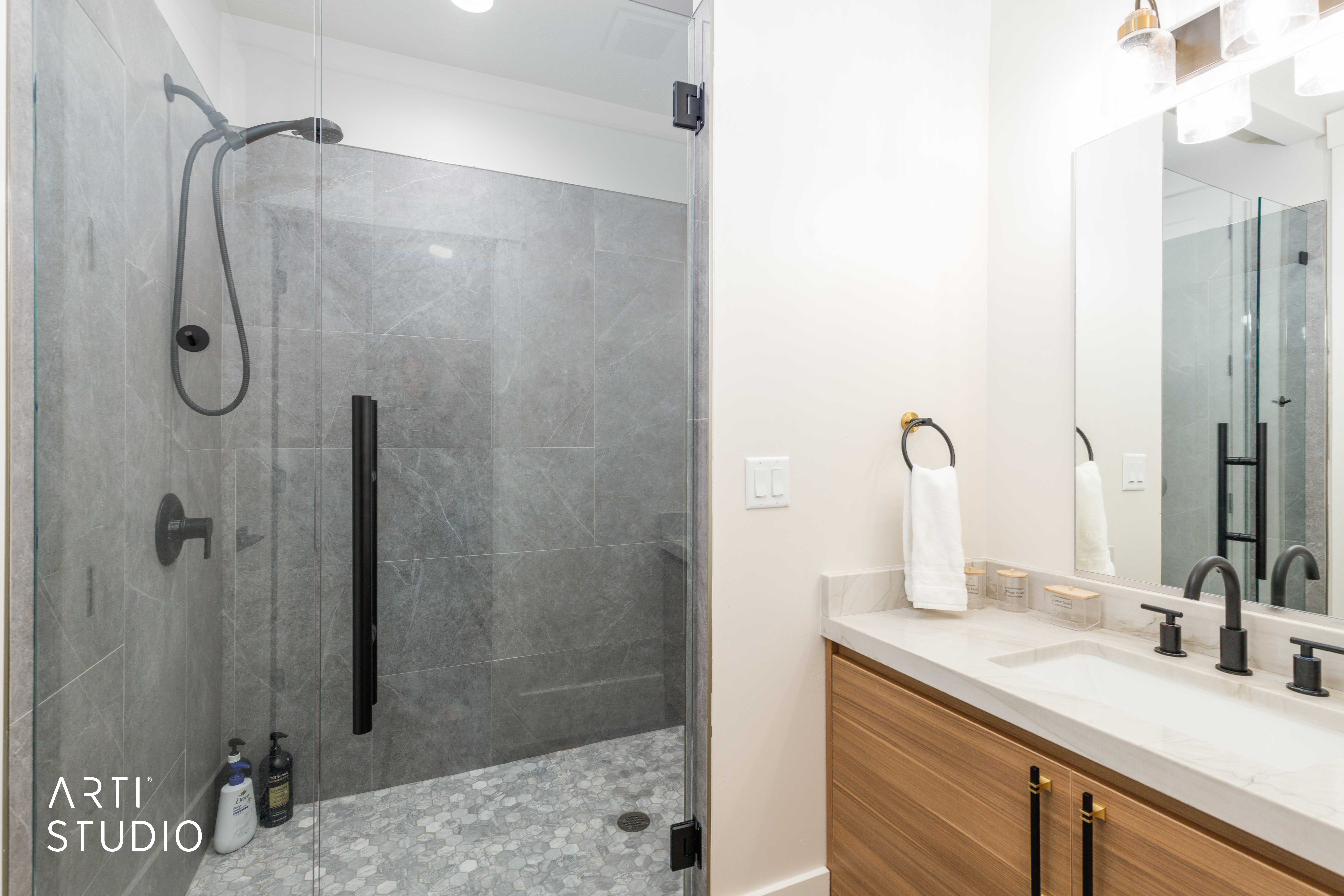 Contemporary bathroom featuring a spacious glass-enclosed shower with large format wall tiling and hexagonal floor tiling