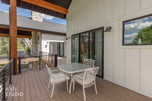 Spacious outdoor deck featuring composite decking, black metal railings, and a board and batten exterior
