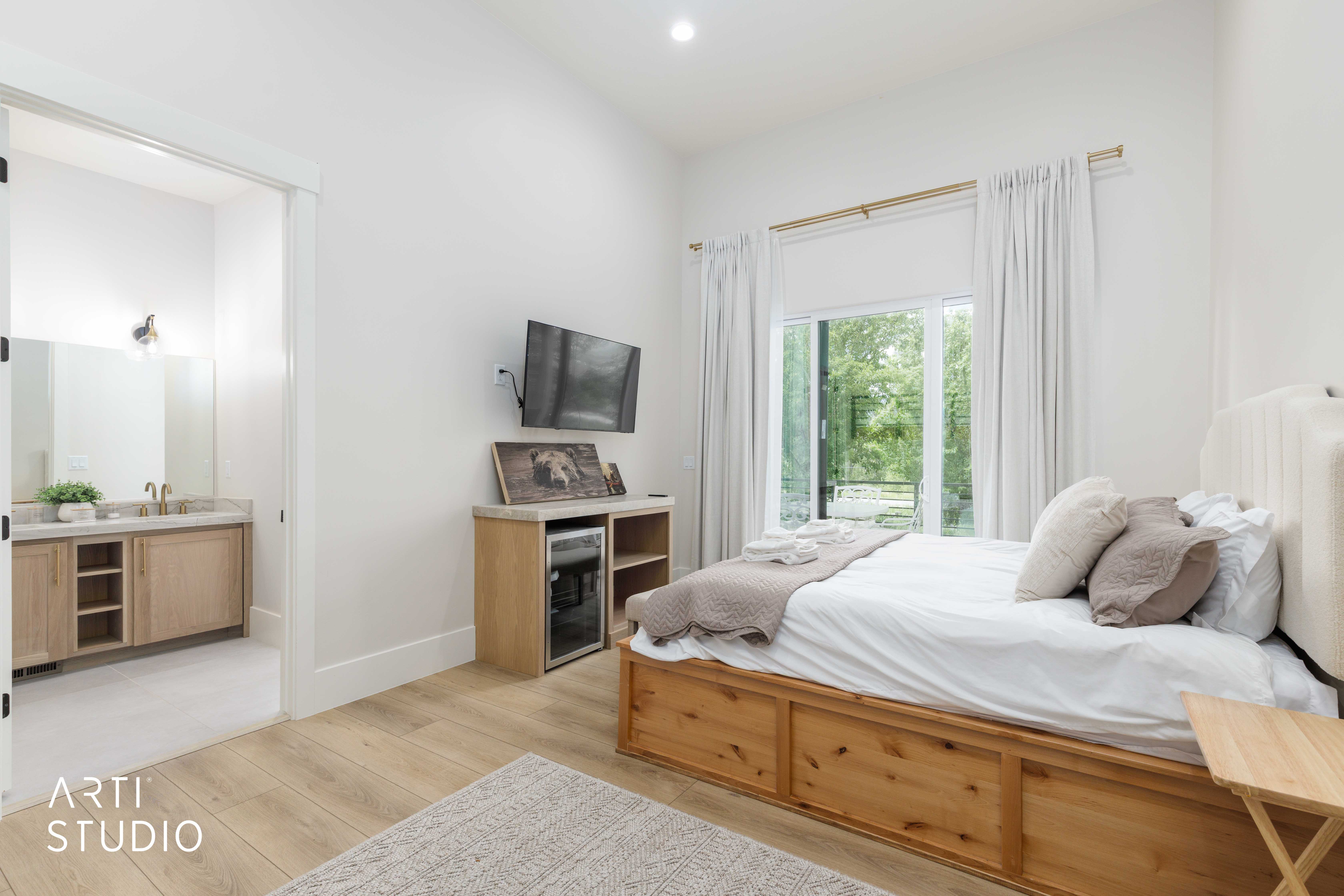 Spacious room with wood-finish flooring, a large sliding glass door, high ceilings, and a built-in beverage refrigerator
