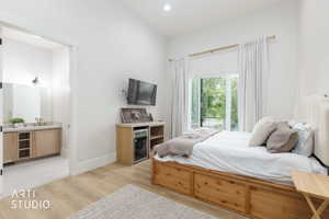 Spacious room with wood-finish flooring, a large sliding glass door, high ceilings, and a built-in beverage refrigerator