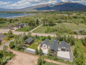 Modern multi-structure property featuring a main residence with an attached three-car garage, a separate barn-style outbuilding, and a gravel driveway