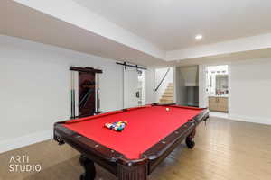 Recreation room featuring wood-finish flooring, recessed lighting, and a built-in cue rack