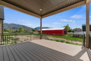 Covered outdoor deck with composite decking and black metal railings
