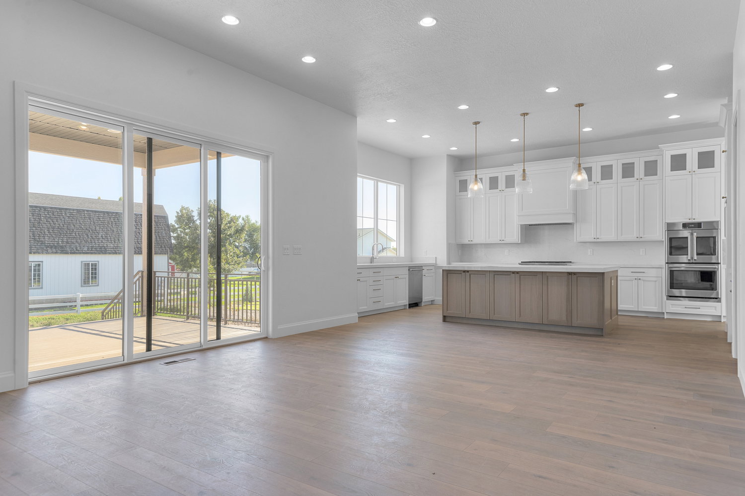 Spacious kitchen and living area featuring wood-finish flooring and recessed lighting