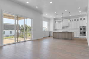 Spacious kitchen and living area featuring wood-finish flooring and recessed lighting