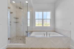 Contemporary bathroom featuring a spacious glass-enclosed shower with pebble-finish flooring and dual showerheads