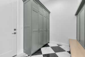 Entryway with tall built-in cabinetry and a wood-finish bench