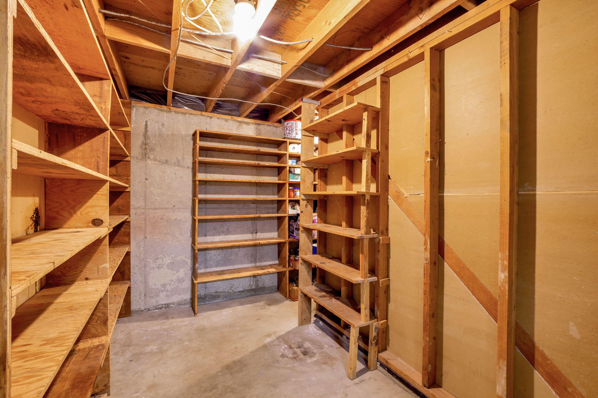Utility space featuring exposed wood ceiling joists and unfinished concrete flooring