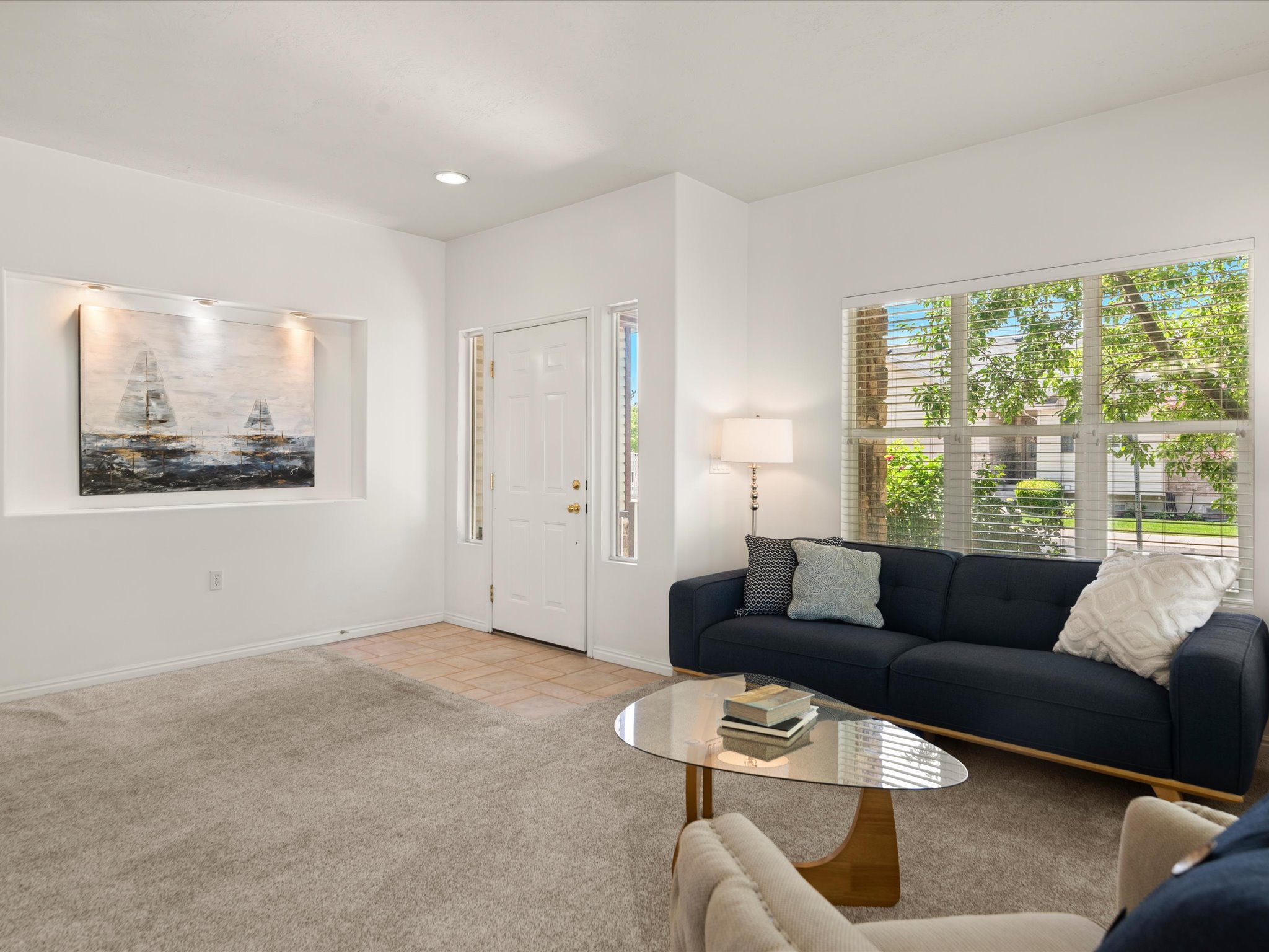 Entry area with a white paneled door featuring sidelight windows, opening to a tiled foyer