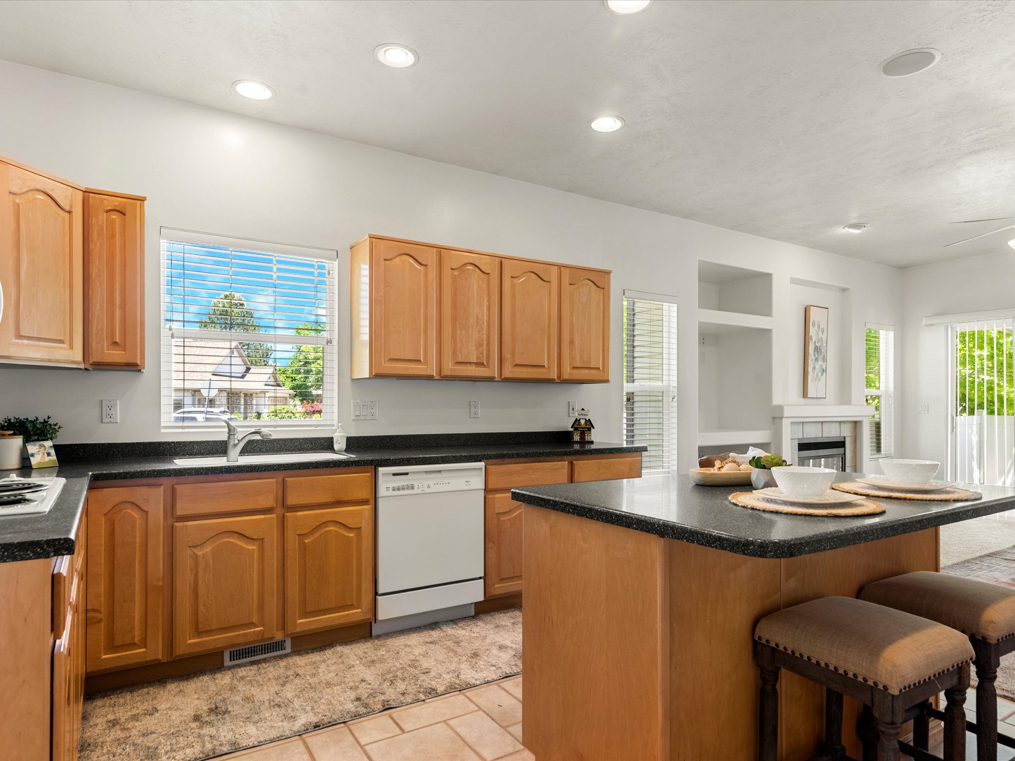 Kitchen featuring wood-finish cabinetry, dark countertops, and a central island with seating