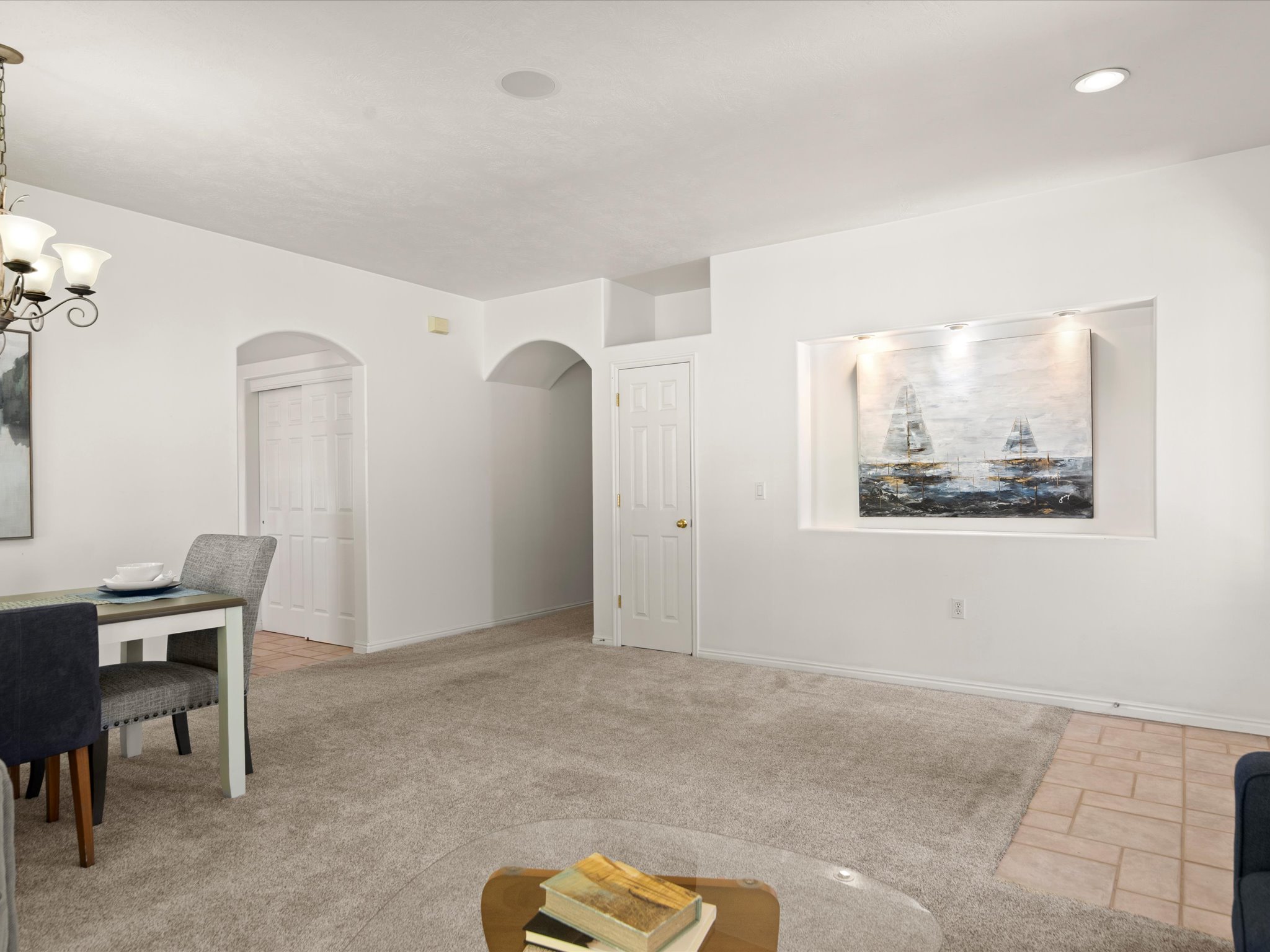Carpeted living space with a recessed art niche featuring integrated lighting