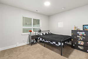 Carpeted room featuring a window with blinds, light gray walls, white baseboards, and an overhead flush-mount light fixture