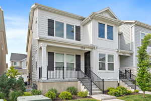 White exterior with contrasting dark shutters and black railings