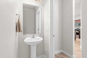 Pedestal sink with chrome faucet, complemented by a rectangular wall-mounted mirror