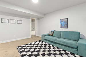 Carpeted room with light gray walls, white baseboards, and overhead lighting
