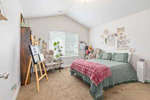 Spacious room featuring vaulted ceilings, light-toned walls, and neutral carpet flooring