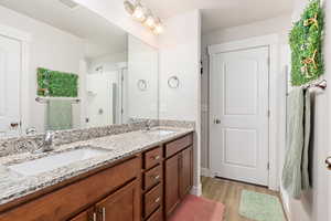 Dual vanity with granite countertops, undermount sinks, and wood-finish cabinetry