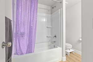 White tub and shower combination with chrome fixtures and integrated shelving
