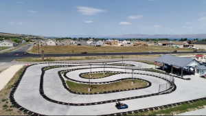 Concrete go-kart track with tire barriers and perimeter fencing