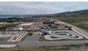Aerial perspective showcasing a sprawling property featuring a go-kart track, miniature golf course, and multiple commercial structures