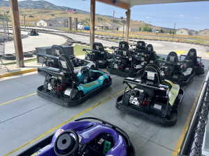 Covered outdoor area featuring multiple go-karts parked on paved ground