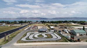 Aerial perspective showcasing a go-kart track with a paved surface and tire barriers