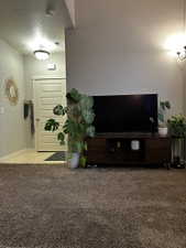 Spacious living area featuring plush carpeting and a neutral wall color