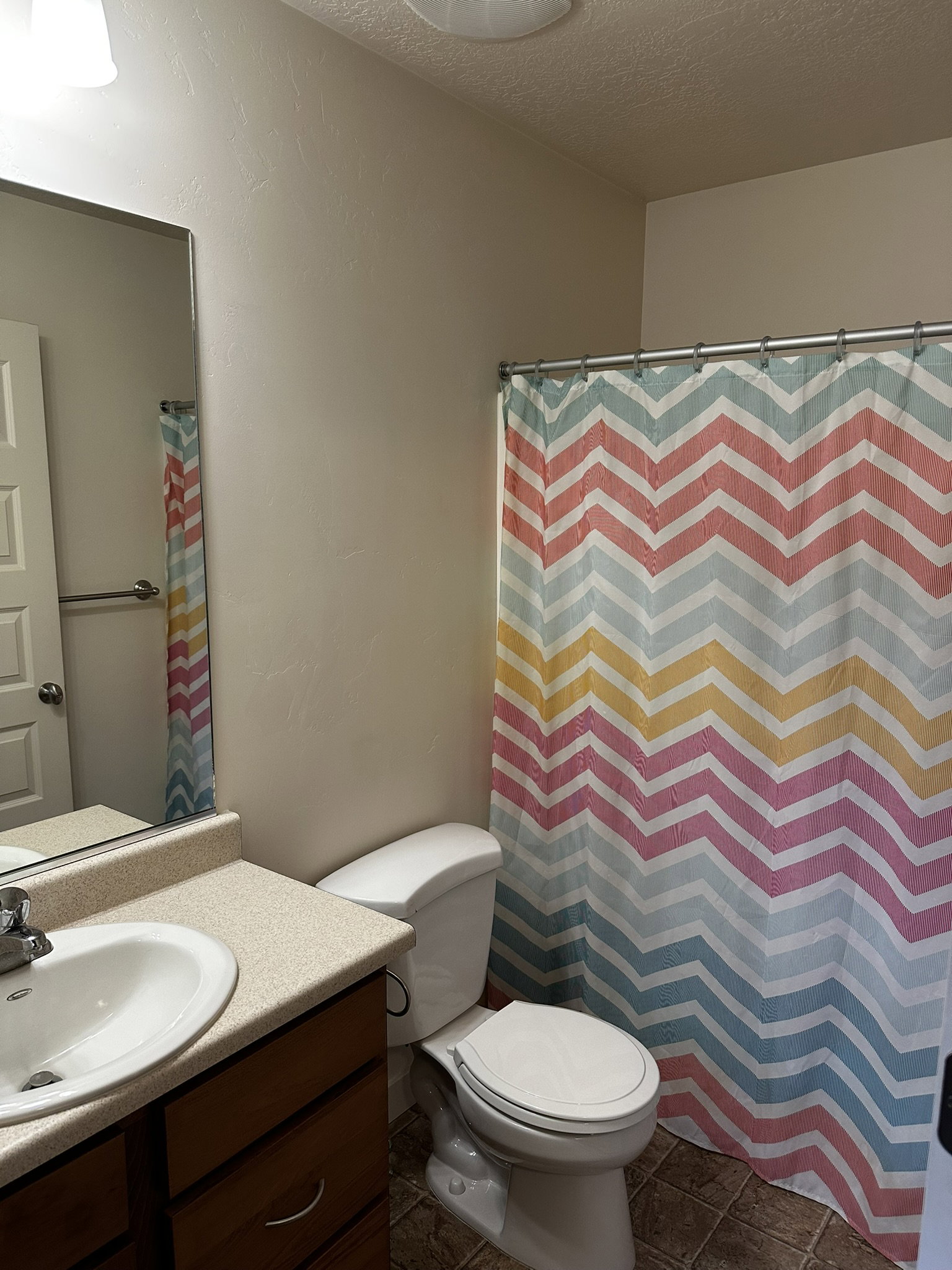 Bathroom featuring a vanity with an integrated sink, laminate countertop, and wood-finish cabinetry