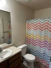 Bathroom featuring a vanity with an integrated sink, laminate countertop, and wood-finish cabinetry