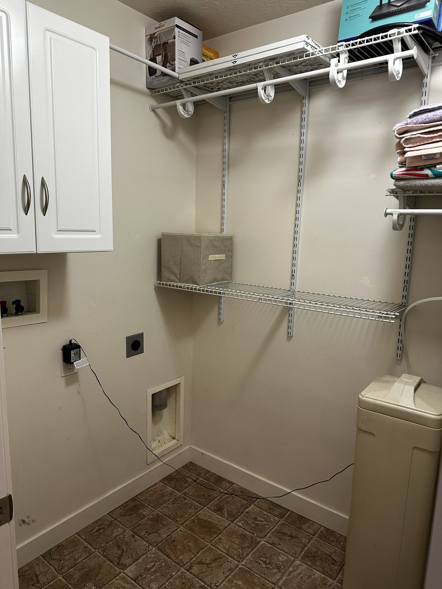 Dedicated utility space featuring tile flooring and neutral wall tones