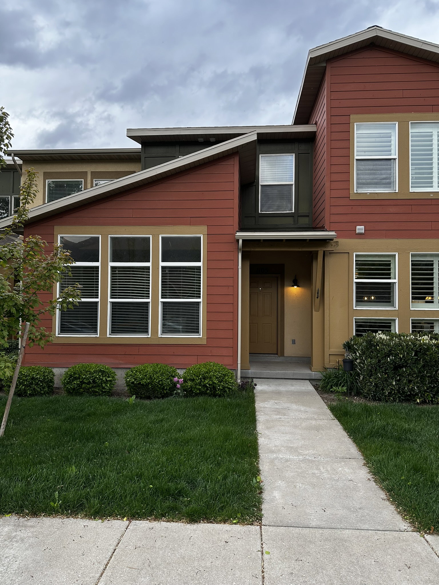 Contemporary multi-level residence featuring a red siding exterior with tan trim accents