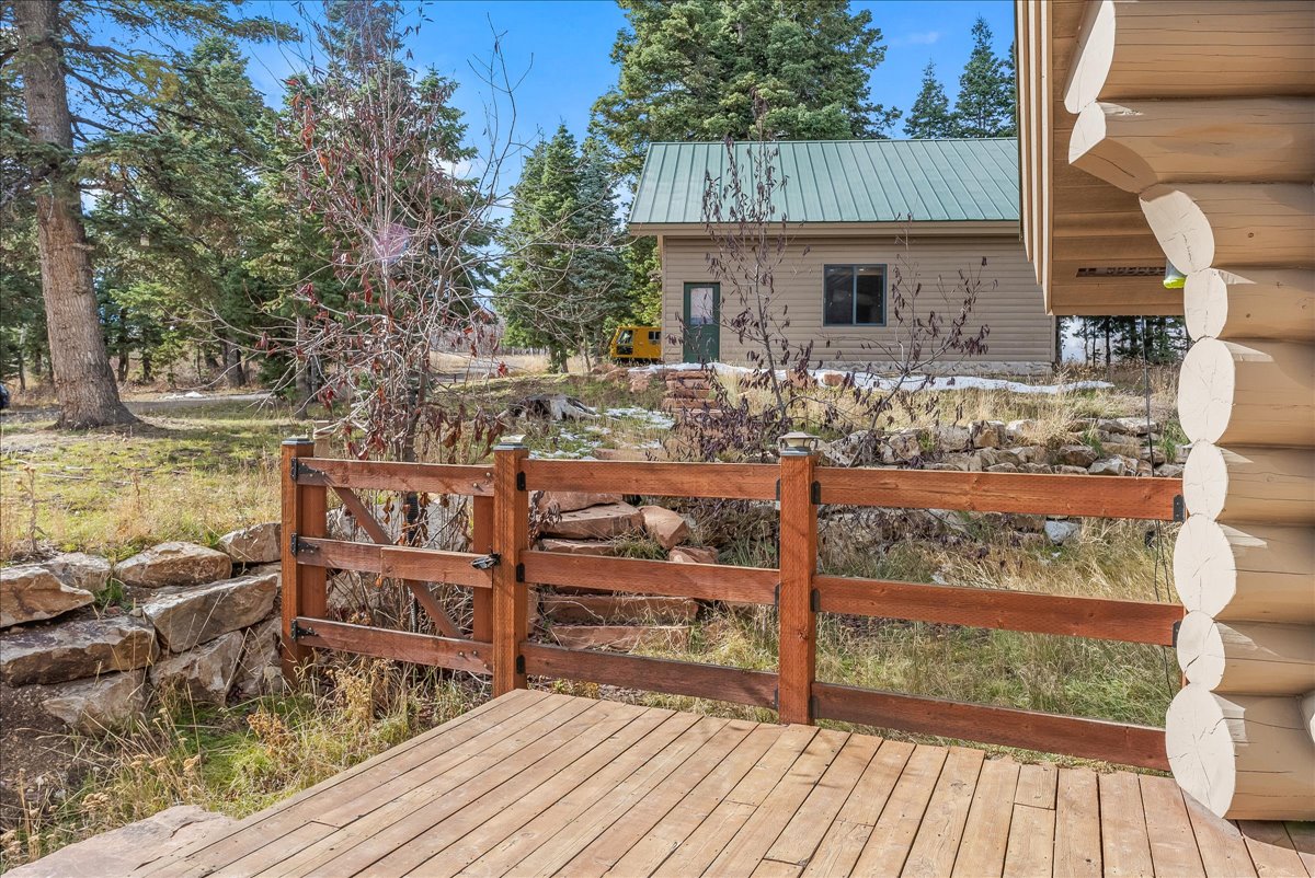 Outdoor decking area featuring a rustic wooden fence and a stone retaining wall