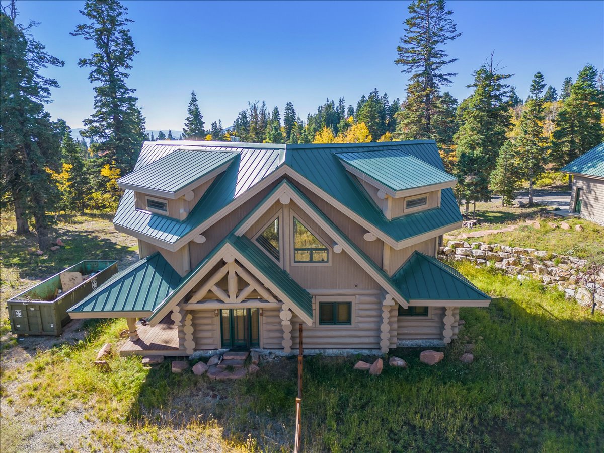 Log-style home featuring a prominent gabled entry with exposed timber framing