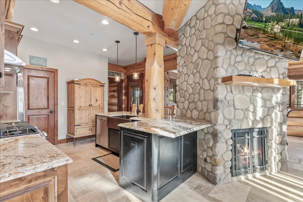 Rustic stone fireplace with a floating wood mantel, integrated into a natural wood beam structure