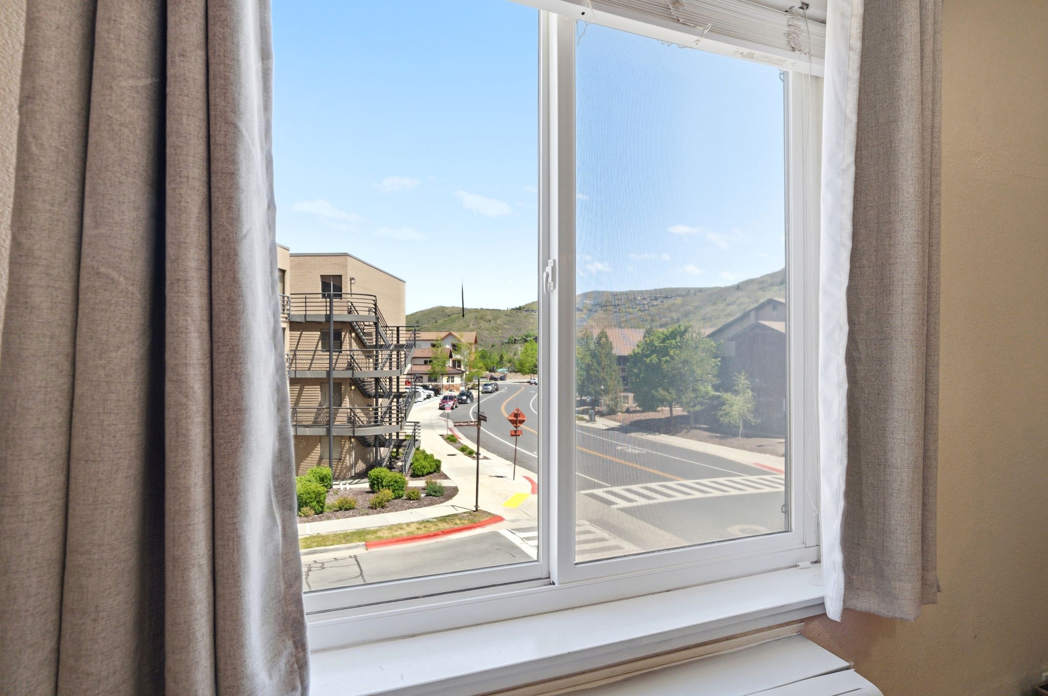 Interior window with white frame, featuring a window sill and neutral-toned curtains