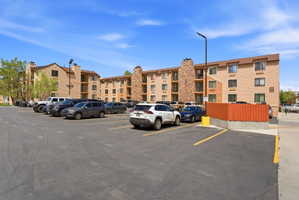 Multi-story residential buildings featuring tan siding, brown trim, and stone veneer accents