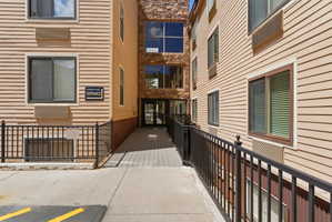 Exterior facade featuring horizontal siding and stone accents, with a ramped entrance leading to a glass-paneled doorway
