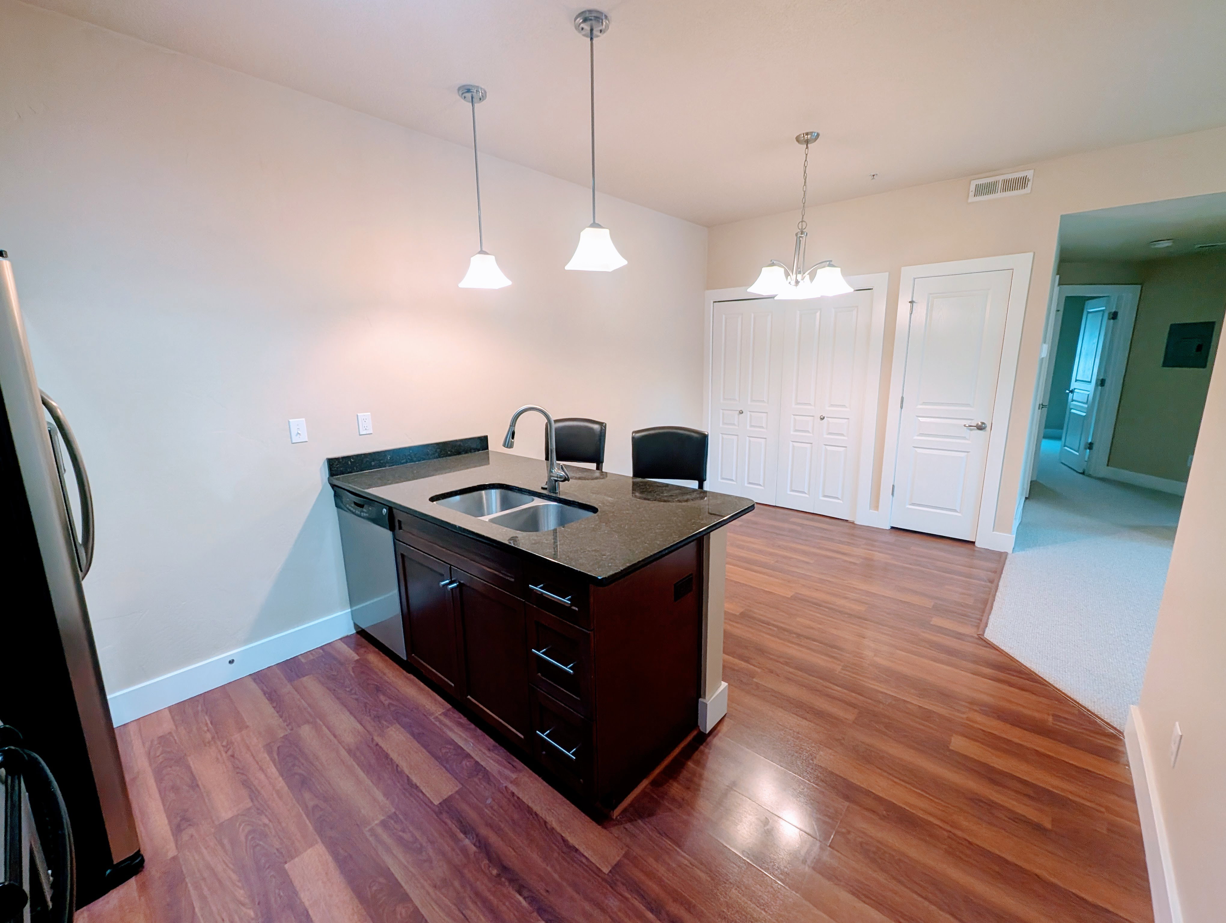 Kitchen island with a double basin sink and a dark countertop