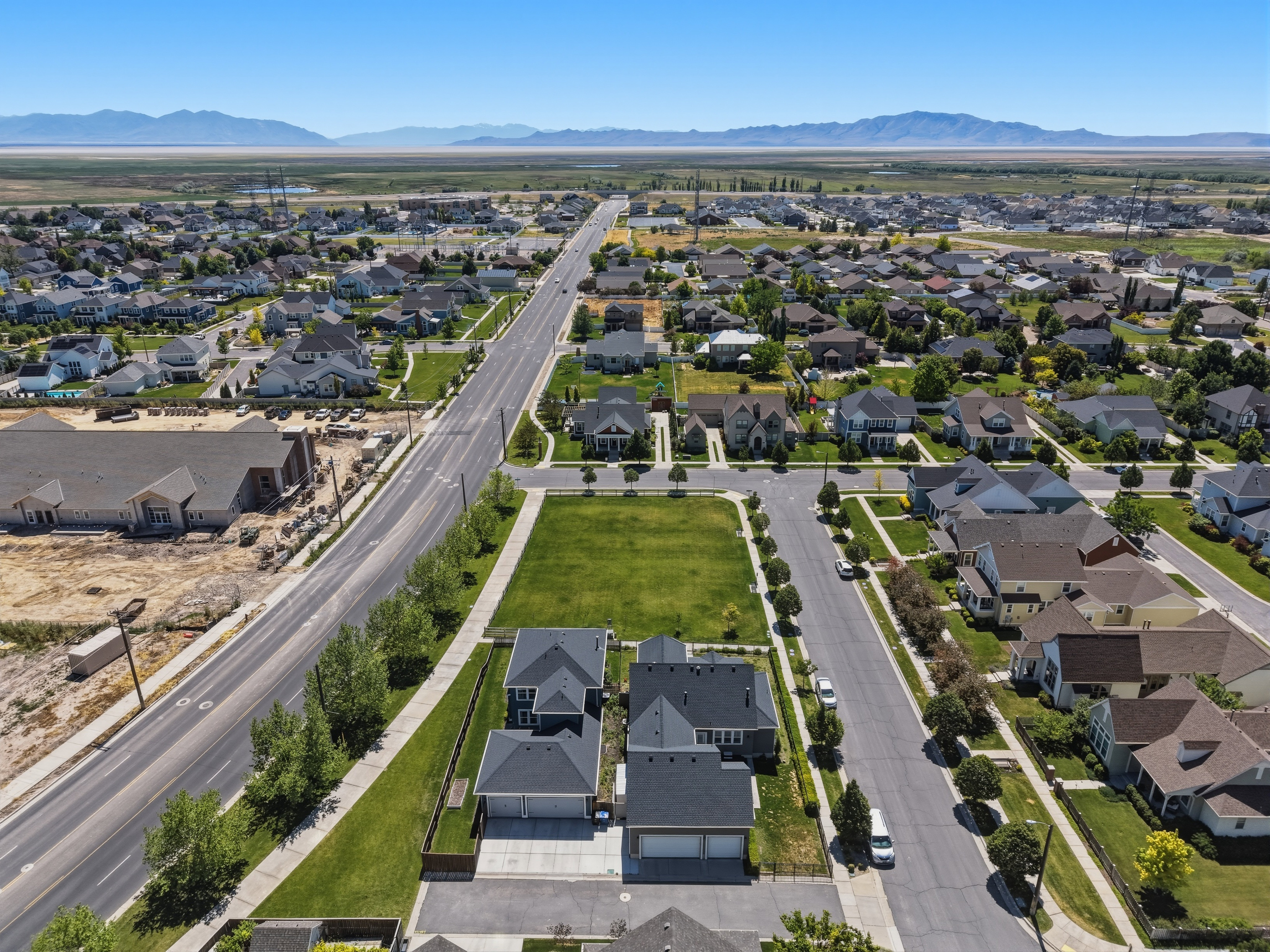 Expansive residential development featuring a broad paved street and surrounding homes